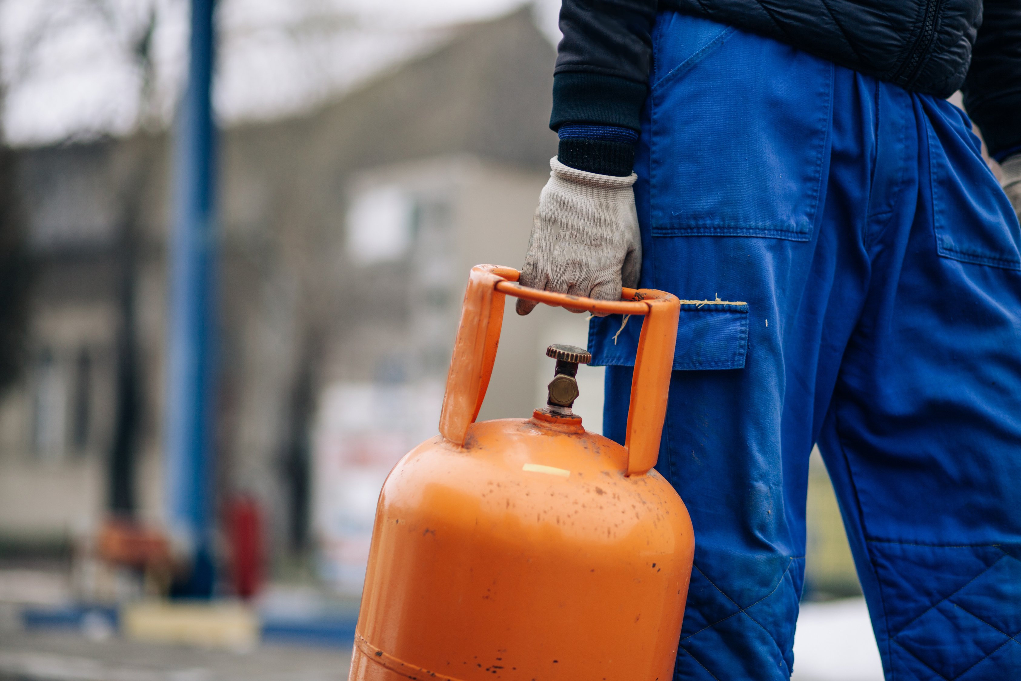 Man carrying LPG gas bottle at gas station